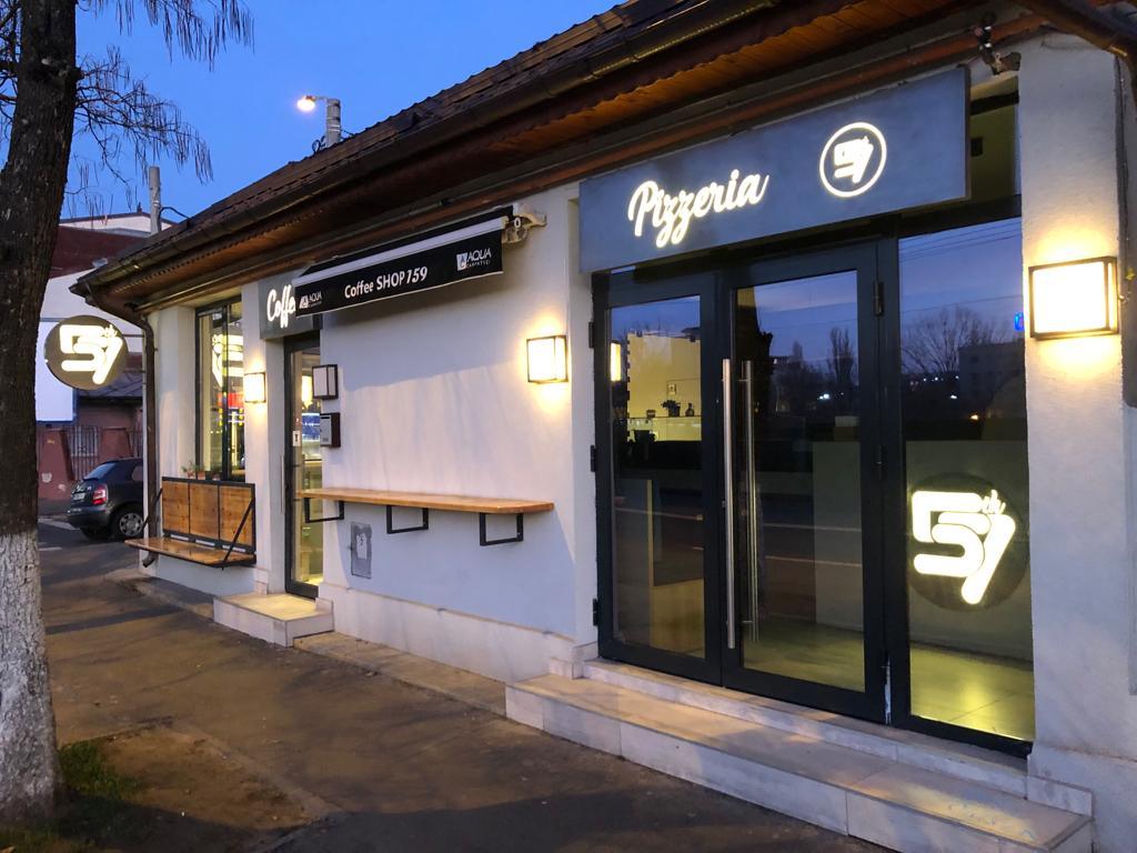 Fațada Pizzeria 57 de pe Strada Jiului, seara, cu firmele Pizzeria și Coffee shop luminate